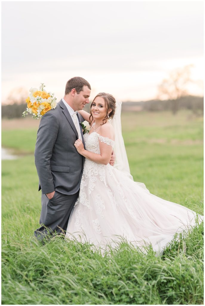 Bride and Groom wedding pose at Emery's Buffalo Creek in Bellville, TX | Yellow Farmhouse style wedding 