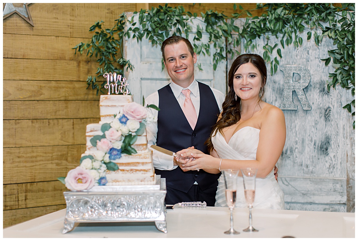 Couple cutting cake at rustic wedding venue | Houston wedding winery venue 
